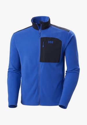 Niebieska polarowa kurtka z czarną zamykaną na zamek kieszenią na piersi, wysokim kołnierzem i kontrastowymi czarnymi panelami na ramionach. Zawiera subtelne detale logo.