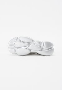 Silver sneaker sole with a textured surface, featuring a bulbous, rounded design and distinct geometric shapes for grip.