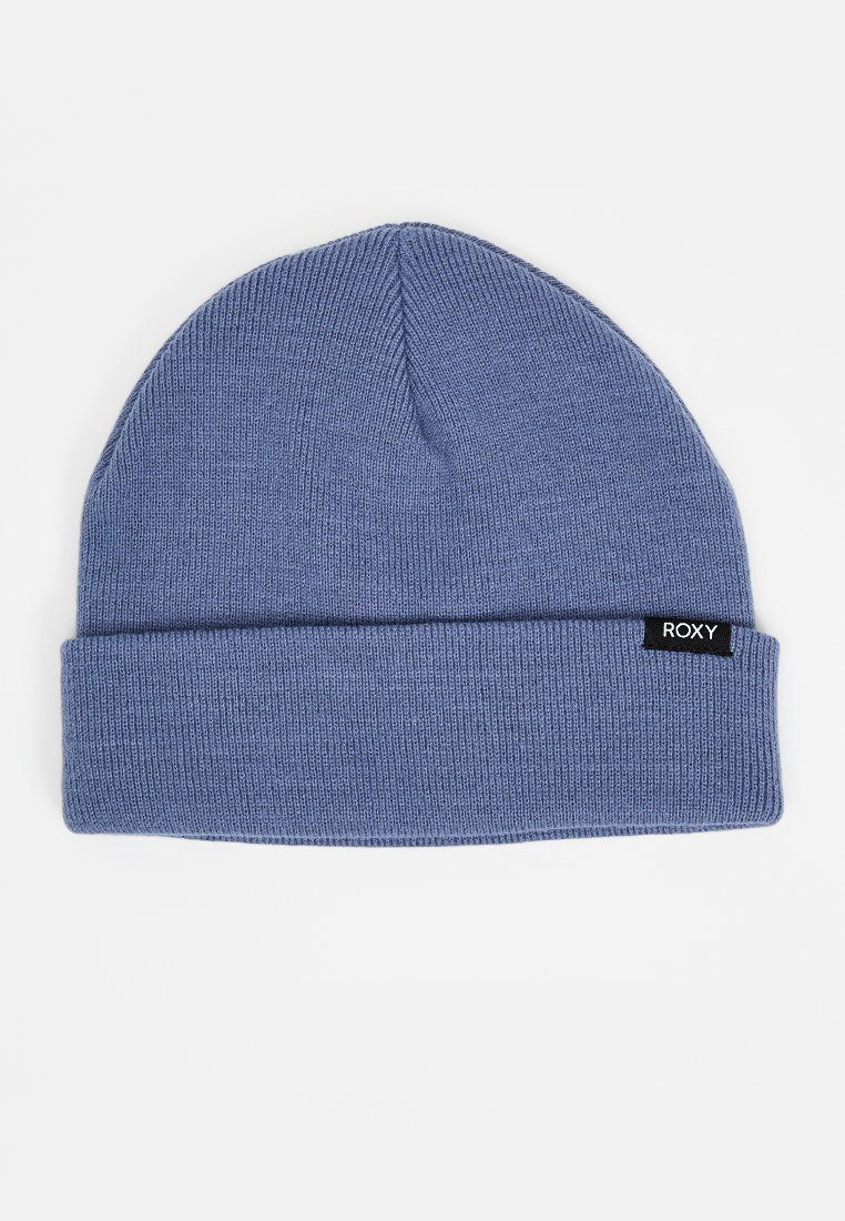 Gebreide beanie in lichtblauw, met een opvouwbare rand en een klein zwart label met witte tekst. De stof heeft een gladde en rekbare textuur.