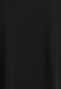 Enhetlig svart tygstruktur med subtila skuggor och veck som antyder ett mjukt, matt material.