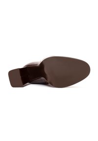 Semelle de chaussure à talons bruns, fabriquée en caoutchouc durable. Le talon a une forme carrée, avec une texture lisse et un contraste de couleur subtil.