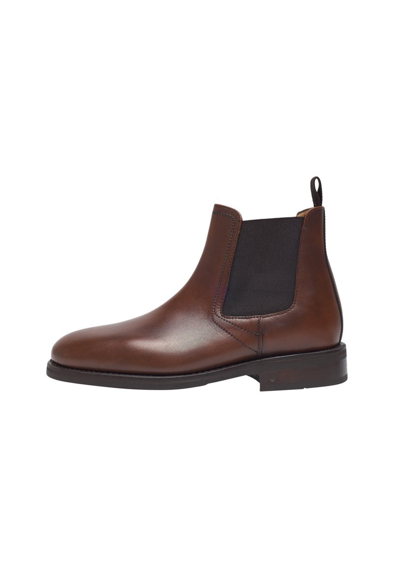 Bottine Chelsea en cuir marron avec des panneaux latéraux élastiques, à bout arrondi et une languette ; texture lisse et détails de surpiqûres subtils sur les coutures.