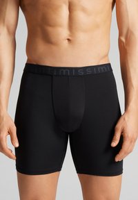 Černé boxerky s pohodlným elastickým pasem s názvem značky. Hladký povrch, těsně padnoucí design a délka do poloviny stehna.