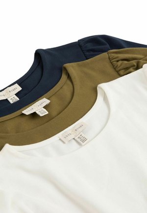 Trīs apkakles T-krekli: tumši zili, olīvzaļi un balti. Katrs no tiem ir izgatavots no mīksta kokvilnas materiāla ar nevienādos etiķetēm kaklā.