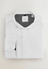 Weißes Langarmhemd aus strukturiertem Stoff. Verfügt über einen klassischen Kragen, eine Knopfverschluss und ein gemustertes Innenfutter in Schwarz und Grau.