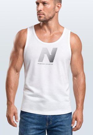 Muskelöser Mann trägt ein weißes ärmelloses Tanktop mit einem gepunkteten „N“-Logo und dem Text „Everyday Athletics“, kombiniert mit blauen Jeans.