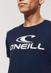 Marineblauwe T-shirt van katoen, met een grote witte O'Neill-logo op de voorkant. Korte mouwen en een klassieke ronde hals.