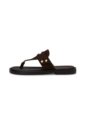 Dunkelbraune flache Sandale mit Zehenriemen, breitem oberen Riemen, der mit zwei goldenen Nieten befestigt ist, und schwarzer Sohle.