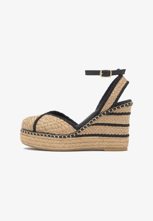 Sandalo espadrillas con zeppa, piattaforma in juta intrecciata, bordo nero e cinturino alla caviglia con fibbia dorata, vista laterale.