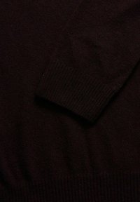 Strickpullover in Dunkelbraun mit gerippten Bündchen und Saum. Weiche Textur, schlichtes Design und klassische Form ohne Muster oder Verzierungen.