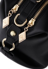 Borsa in pelle sintetica nera con doppie cerniere dorate, hardware circolare e dettagli dorati a forma triangolare. Superficie texturizzata con dettagli dorati.