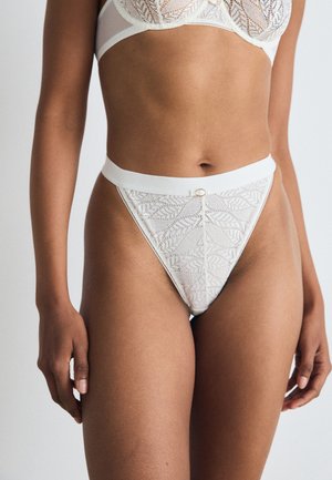 Witte kanten string met bloemenpatroon en een gladde tailleband. Heeft een kleine gouden accent aan de voorkant. Zachte textuur, ontwerp met minimale bedekking.