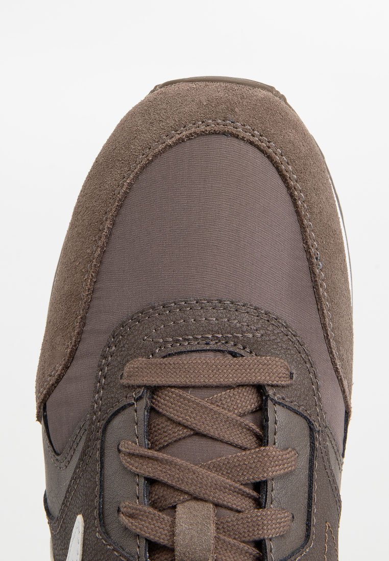 Sneaker marron en cuir suédé et matériaux synthétiques, avec un bout rond, des lacets et un design épuré.