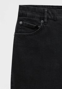 Gros plan sur un jean en denim noir montrant la poche avant, la petite poche à monnaie, le passant de ceinture et les rivets métalliques sur un fond clair.