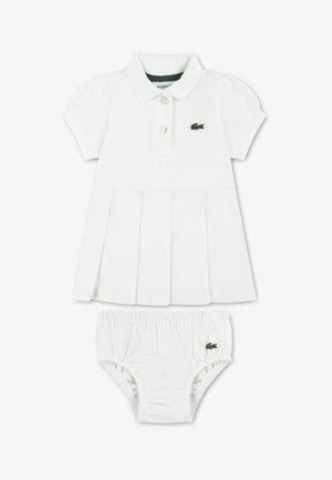 Witte katoenen jurk met een polokraag, pofmouwen en een geplooide rok. Wordt geleverd met bijpassende witte short met elastische tailleband en logo.