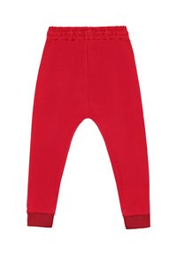 Czerwone spodnie dla malucha z elastycznym pasem i ściągaczami przy nogawkach, ułożone płasko na białym tle.