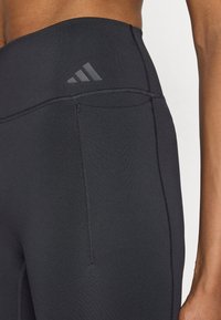 Sorte leggings med høj talje lavet af elastisk materiale. Har flatlock-sømme og en diskret logo i linningen for ekstra detaljer.