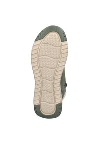 Schoenzool met een gestructureerde beige rubberen basis en groene accenten. Kenmerkt zich door een golfpatroon voor grip en een ronde vorm voor flexibiliteit.