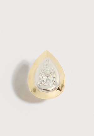 Traanvormige gouden ring met een grote heldere peer geslepen edelsteen, gezet in een gepolijste zilverkleurige rand.