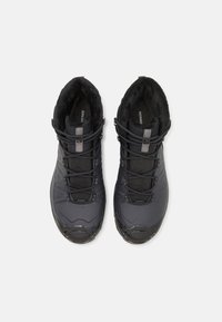 Black waterproof hiking boots with a textured upper, soft lining, and elastic laces. Reinforced toe and heel for durability.