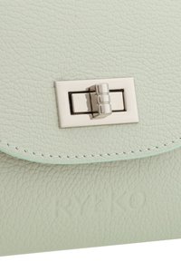 Mint-vihreä nahkalaukku, jonka pinnassa on tekstuuria, varustettuna metallisella suljennalla ja kohokuvioidulla brändäyksellä. Ompeleet reunassa lisäävät yksityiskohtia.