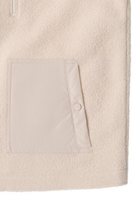 Polarowy sweter w jasnym beżu z fakturowanym wykończeniem. Posiada beżową kieszeń z nylonu z zapięciem na zatrzask z przodu.