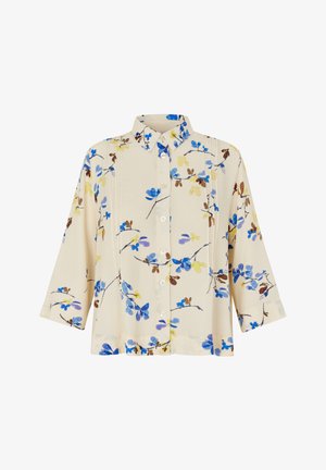 Blomstret skjorte med knapper lavet af letvægtsstof, med blå, gule og brune blomster på en cremefarvet baggrund, og trekvart ærmer.