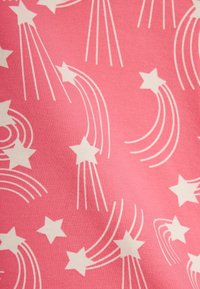 Tela rosa con patrón de estrellas fugaces blancas y líneas curvas en movimiento.
