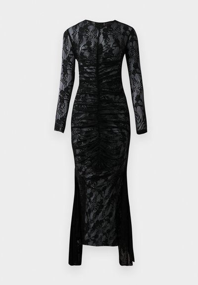 Långärmad svart klänning med en figursydd silhuett, rynkad tyg och blommig spetsöverdrag. Har ett sprund längst ner för extra detalj.