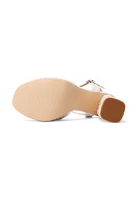 Sandal con tacco alto bianco, dotato di una suola in gomma beige texturizzata. Presenta una fascia regolabile e un sottile dettaglio intrecciato lungo il bordo.