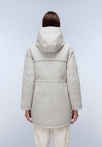 Parka ligera aislante de color gris claro con capucha, cintura elástica y bolsillos. Textura suave y diseño simple.