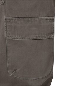 Grauer Cargo-Stoff mit einer Seitentasche, die sichtbare Nähte und eine glatte Textur aufweist. Die Tasche hat eine rechteckige Form und gerade Kanten.