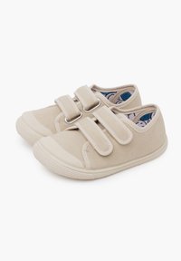 Scarpe in tela beige con doppie strap in Velcro, suole in gomma e una fodera interna a fantasia. Punta arrotondata e suola testurizzata per una maggiore aderenza.