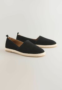 Musta mokkanahkainen liukuspikka espadrilles, jossa on kudottu juuttipohja, pyöreä varvas ja minimaalinen ompelutaito. Varustettu pienellä korolla ja takana vetotarralla.