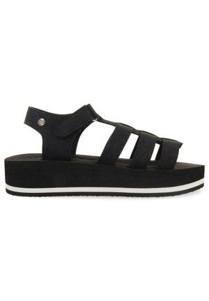 Sandalias de plataforma negras con correas ajustables, textura suave y una franja blanca contrastante en la suela. Diseño moderno y abierto.