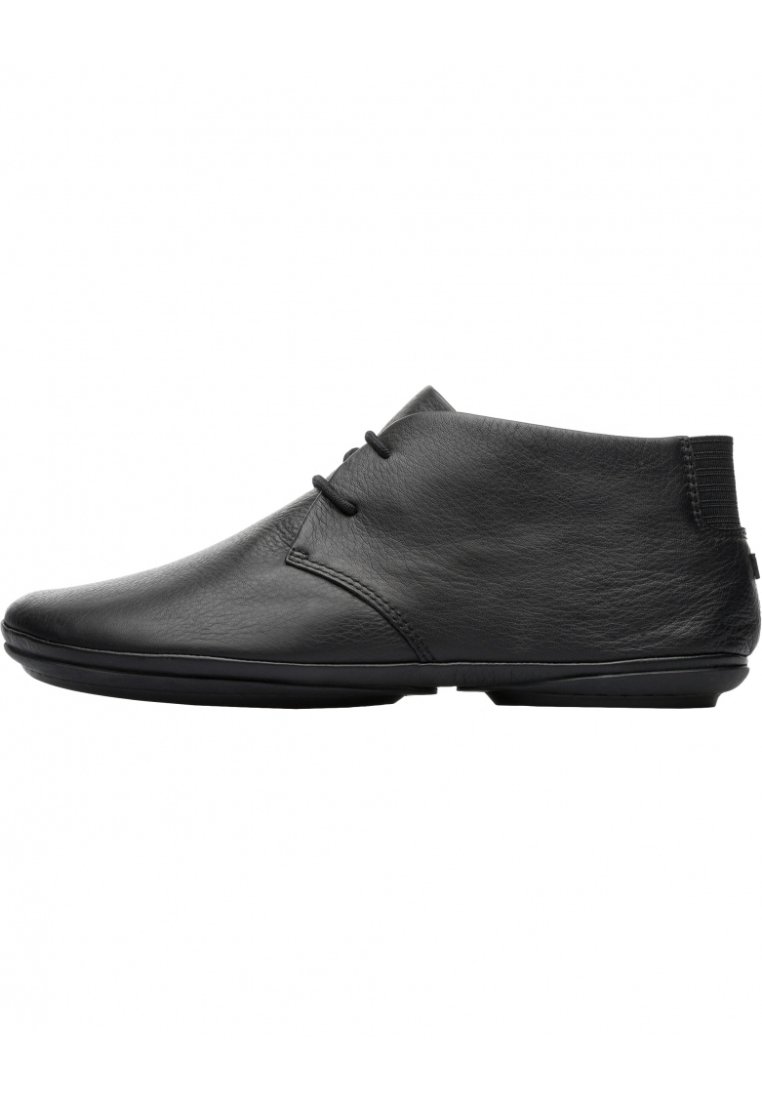 Stivali alla caviglia in pelle nera con una texture liscia, punta rotonda e design minimalista. Presentano cuciture sottili e accenti elastici.