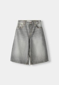 Shorts de mezclilla gris de pierna ancha con efecto desgastado, botón frontal, cremallera, pasadores para cinturón y bolsillos delanteros y de moneda, dispuestos sobre un fondo claro.