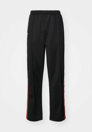 Schwarze Sporthose mit glatter Textur, die rote Seitenstreifen und Druckknöpfe entlang der äußeren Nähte aufweist. Elastischer Bund für zusätzlichen Komfort.