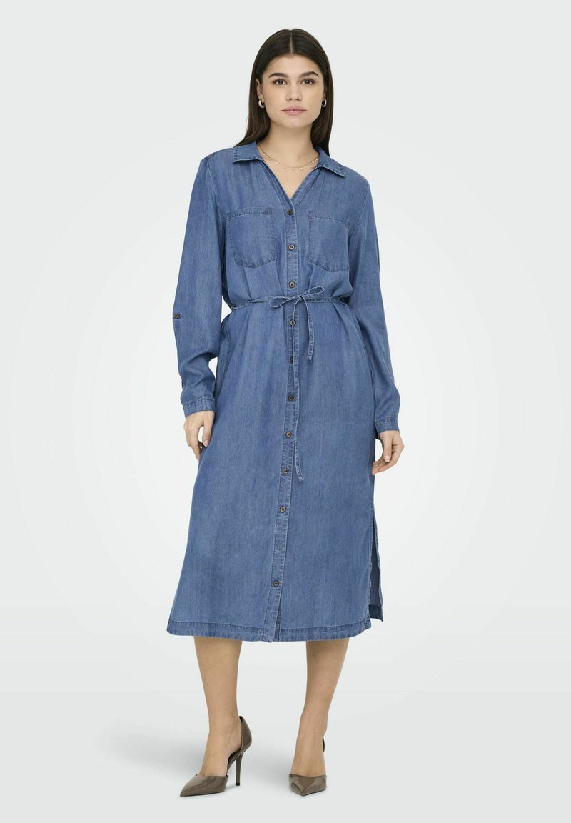 Ett denimklänning med krage, långa ärmar, knäppning fram, två bröstfickor, knyt i midjan och sidofickor. Mellanlängd, blå färg.