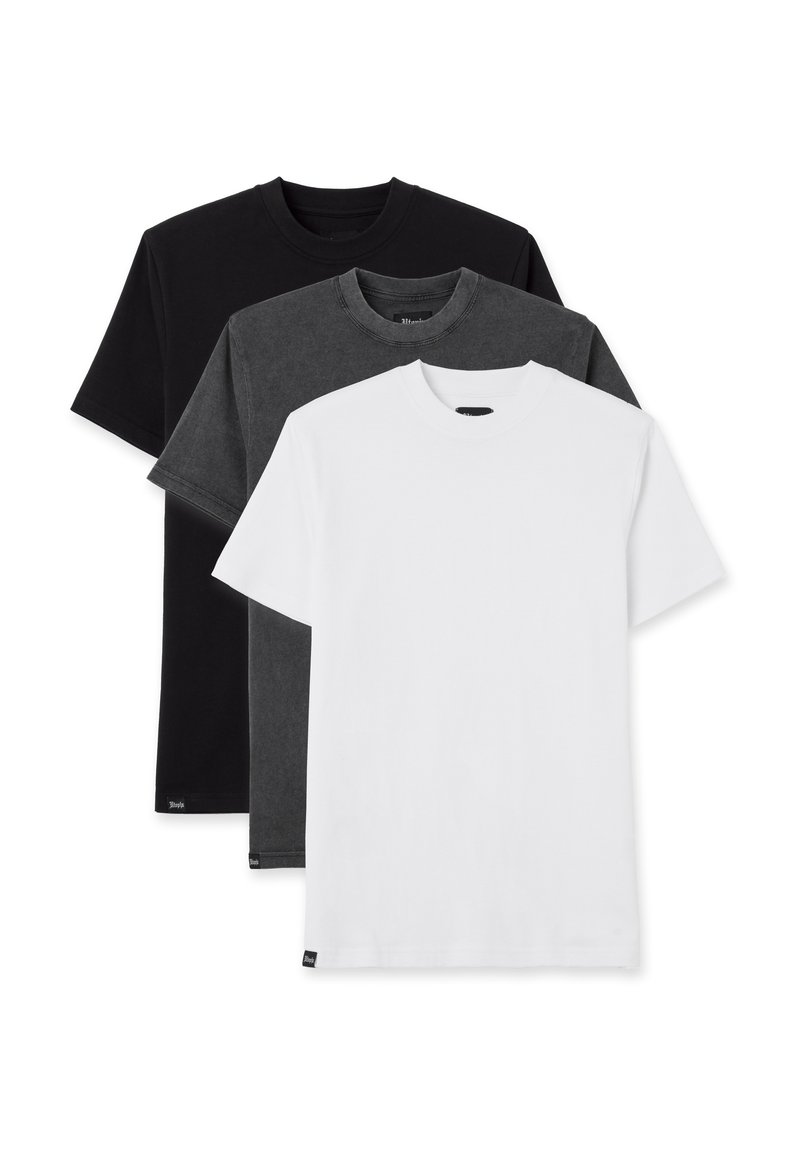Tre t-shirt: nere, grigio heather e bianche. Ognuna ha un collo tondo, maniche corte e una consistenza morbida in cotone. Etichette visibili all'orlo.