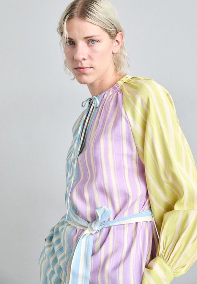 Multicolored striped dress featuring lavender, light green, and blue hues. Made of lightweight fabric, with a tie waist and puffed sleeves.