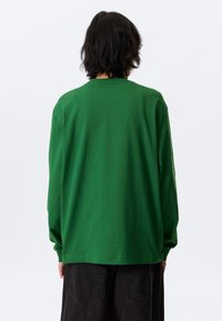 Long-sleeve green T-shirt, made of soft cotton, featuring a classic crew neckline and relaxed fit, shown from the back with no visible details.
