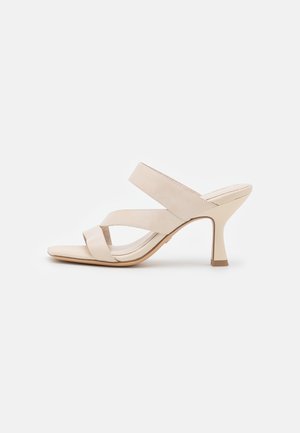 Beige højhælede sandals med tre brede remme, en glat overflade, åben tå og en affaset hæl, der har et minimalistisk design.
