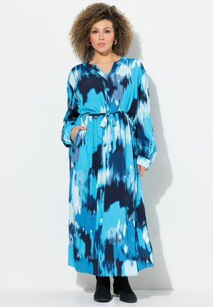 Vestido largo y fluido con un patrón abstracto en azul y marino, con escote en V, mangas largas, cintura ceñida y bolsillos laterales.