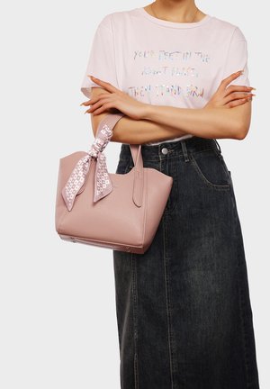 Borsa in pelle rosa con una finitura testurizzata e una sciarpa stampa legata al manico. La borsa ha due manici robusti e una forma strutturata.