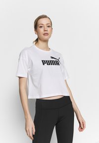 Balta trumpa t-pala su trumpomis rankovėmis, ant kurios kairėje peties pusėje yra didelis juodas "PUMA" logotipas ir juodos katės siluetas.