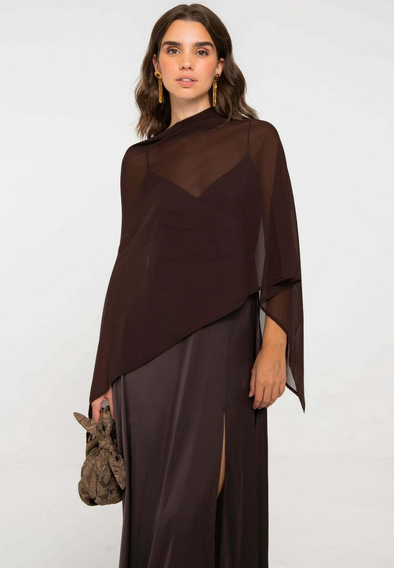 Vestido de noche marrón de satén con superposición transparente, escote en V, mangas largas y abertura lateral. Accesorios incluyen un bolso de mano marrón con estampado.