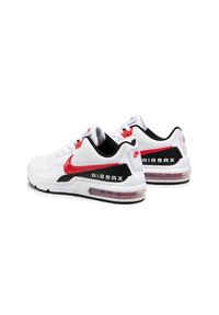 Zapatillas deportivas blancas con un logo Swoosh rojo y detalles en negro. Presentan una unidad de amortiguación Air Max y una suela de goma negra texturizada.