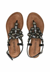 Sandali neri con perline caratterizzati da una trama decorativa, una soletta in suede marrone e cinturini alla caviglia, con dettagli in argento e metallo.