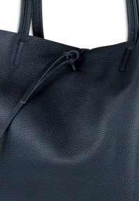 Donkerblauwe leren shopper met een gestructureerd oppervlak, voorzien van twee handvatten en een trekkoordsluiting. Eenvoudig, functioneel ontwerp.